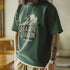 Person wearing a green t-shirt with 'Seaside Oregon' print indoors.
